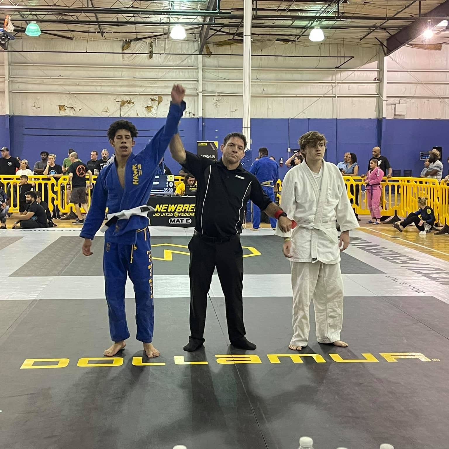 A referee raising a Mad Dog Elite competitor's hand at a tournament