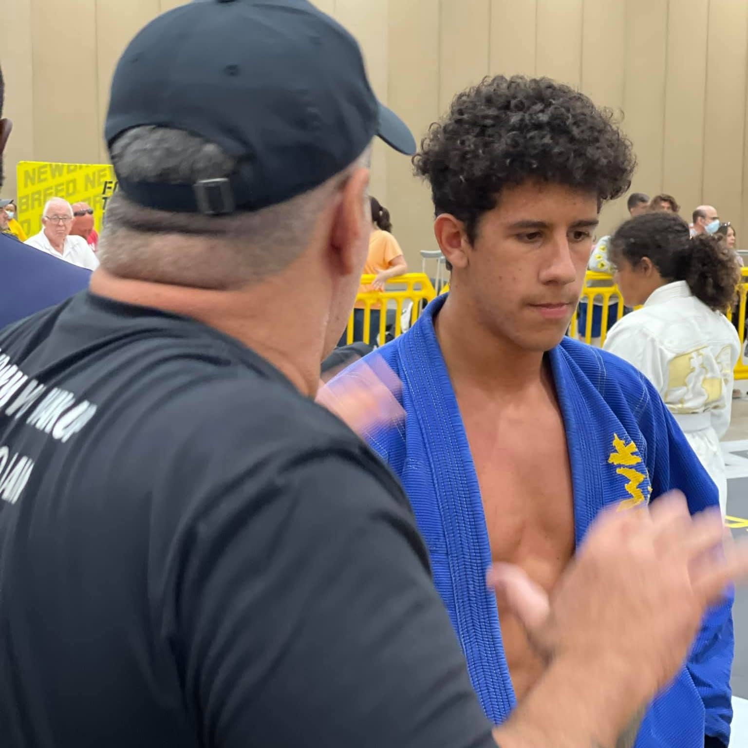 A Mad Dog Elite coach talking with a competitor in the corner at a tournament