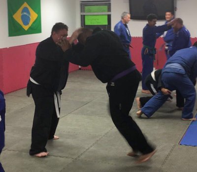 A stand-up self-defense drill in the gi during a live class